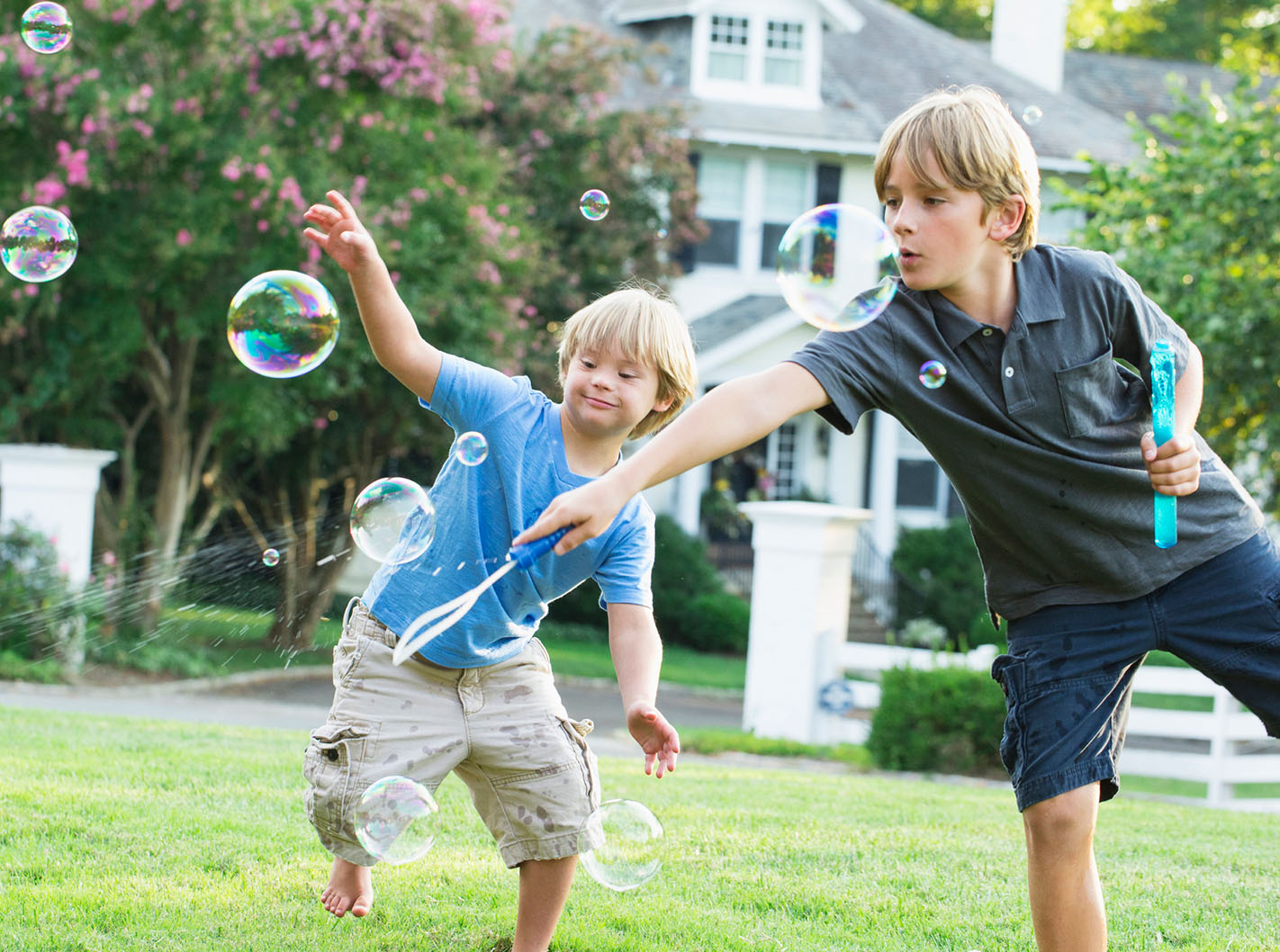 two boys playing with bubbles outside
